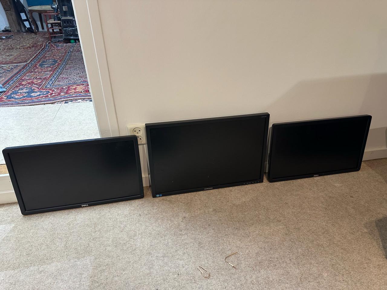 Drie monitors (2 Dell, 1 Samsung) met arm en standaards
