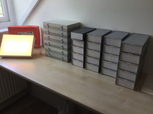 Dia boxen en houders met honderden diaraampjes en dia-viewer.