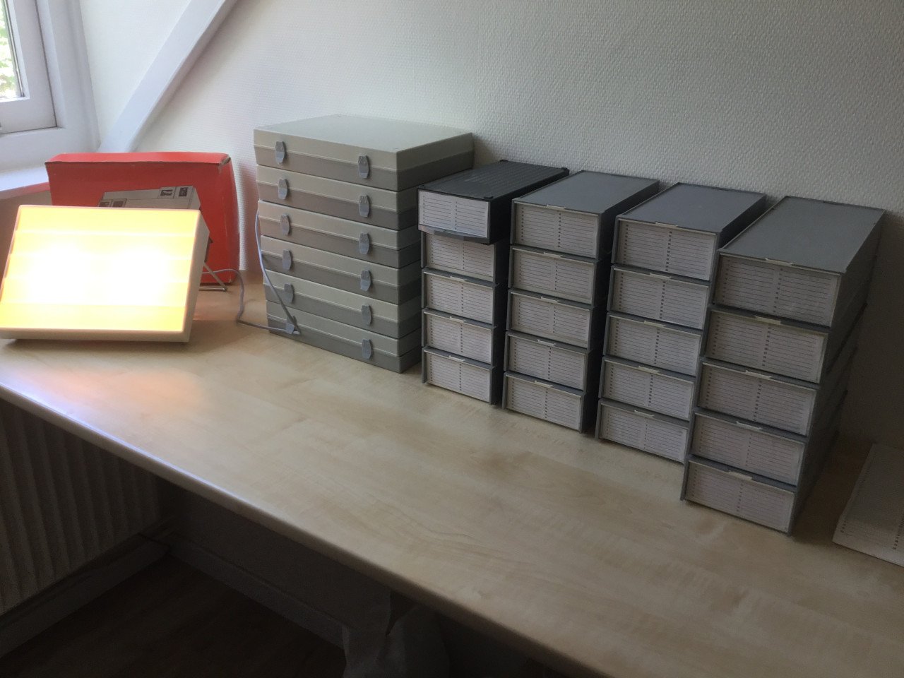Dia boxen en houders met honderden diaraampjes en dia-viewer.