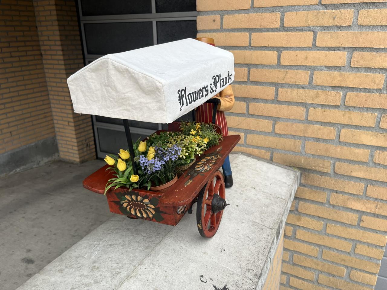 Miniatuur bloemkarretje met pop