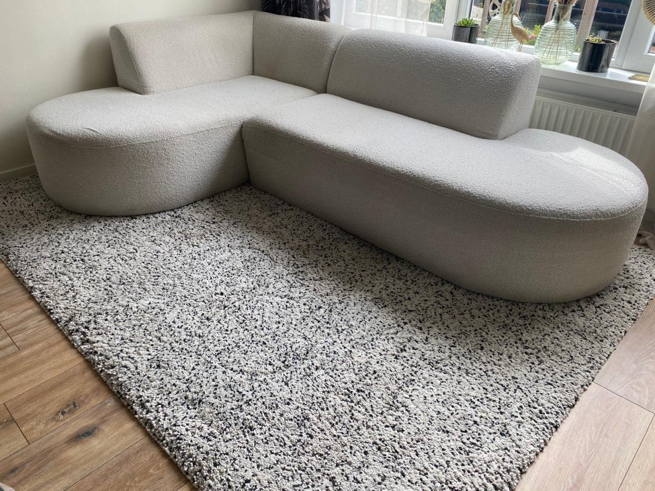 Mooie trendy crèmekleurige hoekbank, teddystof