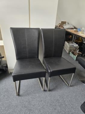 Zwarte leren eetkamerstoelen en fauteuil met poef