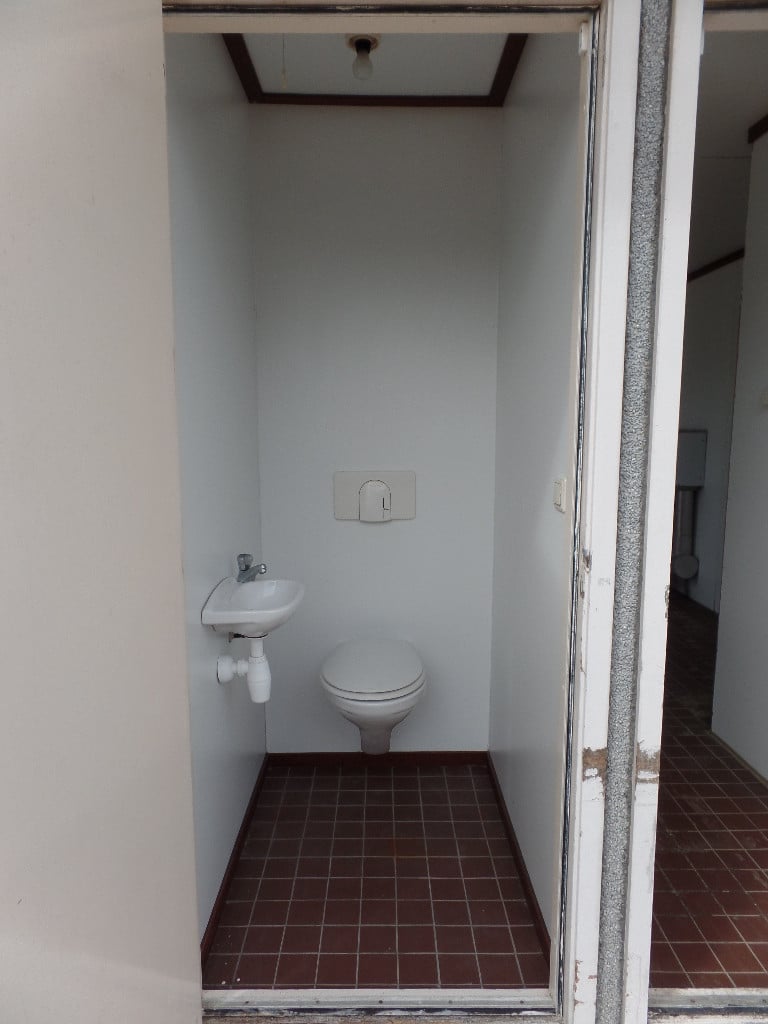 Verkoopunit met betonnen vloer, apart toilet met wastafeltje en rolluik