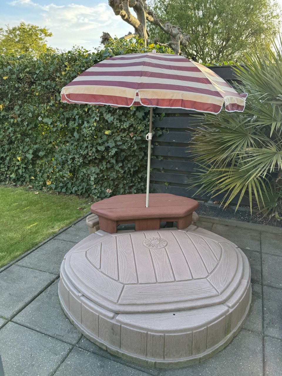 Zandbak met bankje en parasol