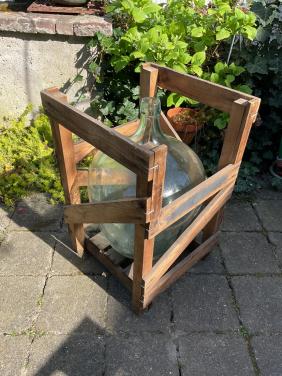 Grote oude fles in krat