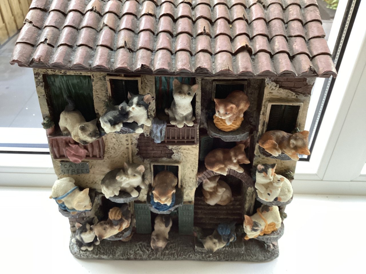 Stenen kattenluik met katten beeldjes
