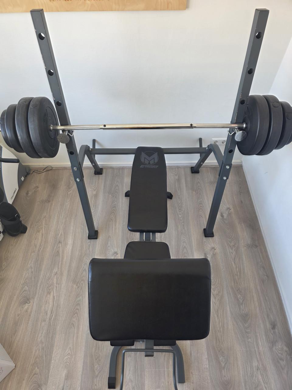 Fitnessbank met halterstang en gewichten