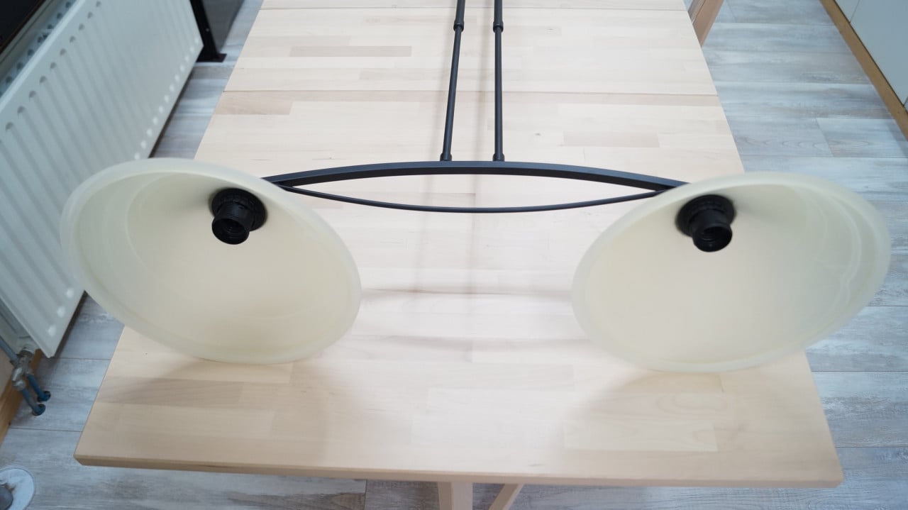 Zwart metalen hanglamp met 2 melkglazen kappen.