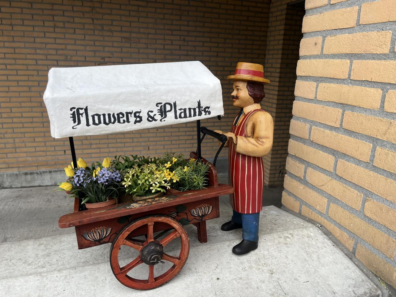 Miniatuur bloemkarretje met pop