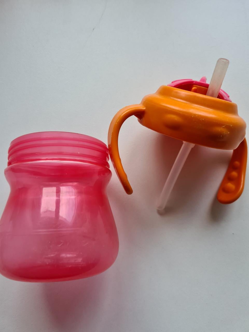 Munchkin Tip & Sip rietjesbeker met oranje deksel en roze beker.