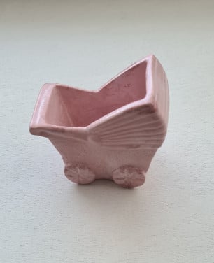 Schattig klein roze bloempotje in de vorm van een kinderwagen