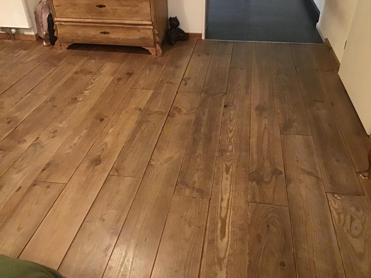 Doorleefde grenen vloer en keuken met koelkast/oven/kookplaat