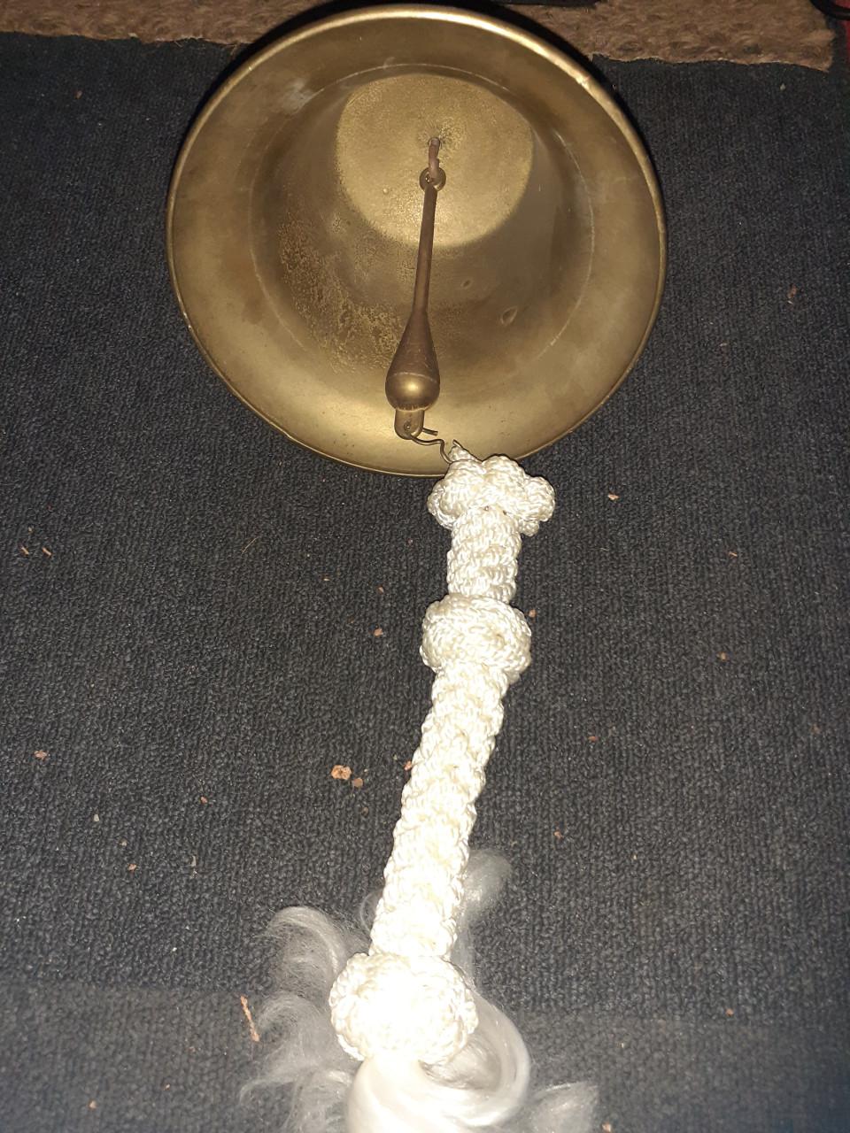 Scheeps bel koper met kort eindje gevlochten touw