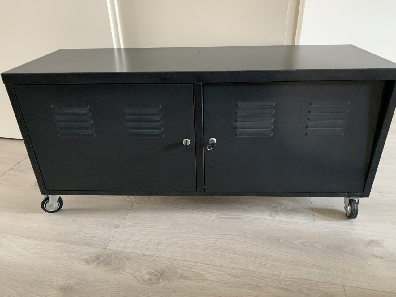 Tv kastje zwart aluminium met deurtjes, en een boord erin, en wieltjes eron