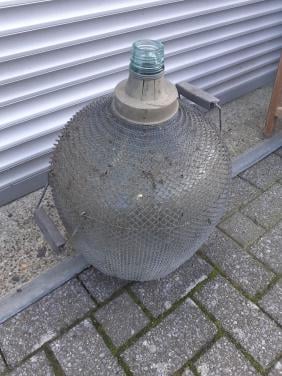 Brocante grote gistfles /wijnfles in ijzeren omhulsel spiraal
