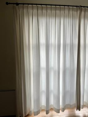 Mooie crèmekleurige gordijnen met zwarte roedes