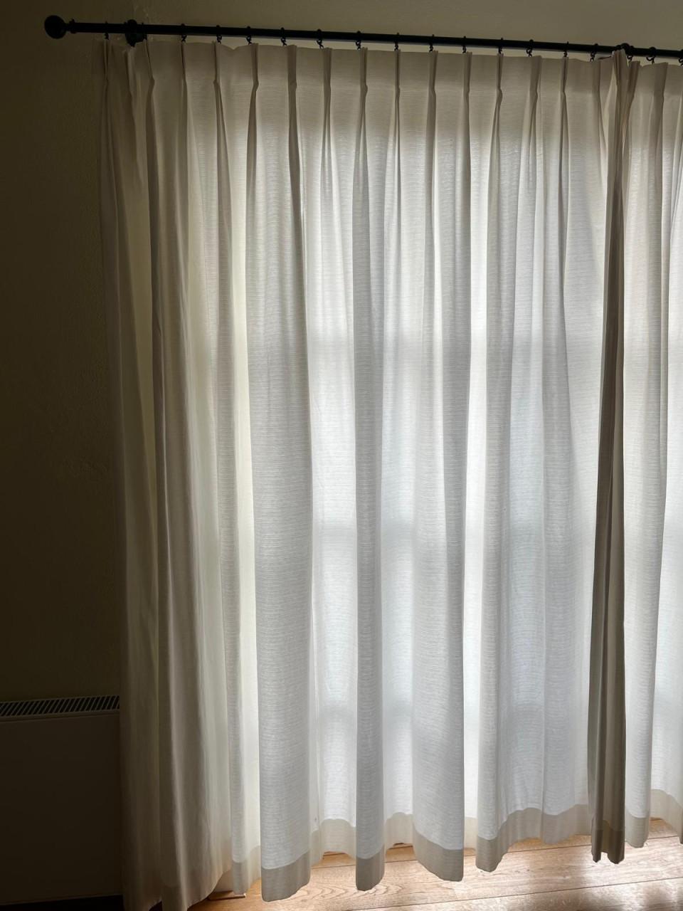 Mooie crèmekleurige gordijnen met zwarte roedes