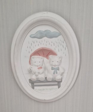 Schattige wanddecoratie van gips met 2 beertjes op een bankje in de regen