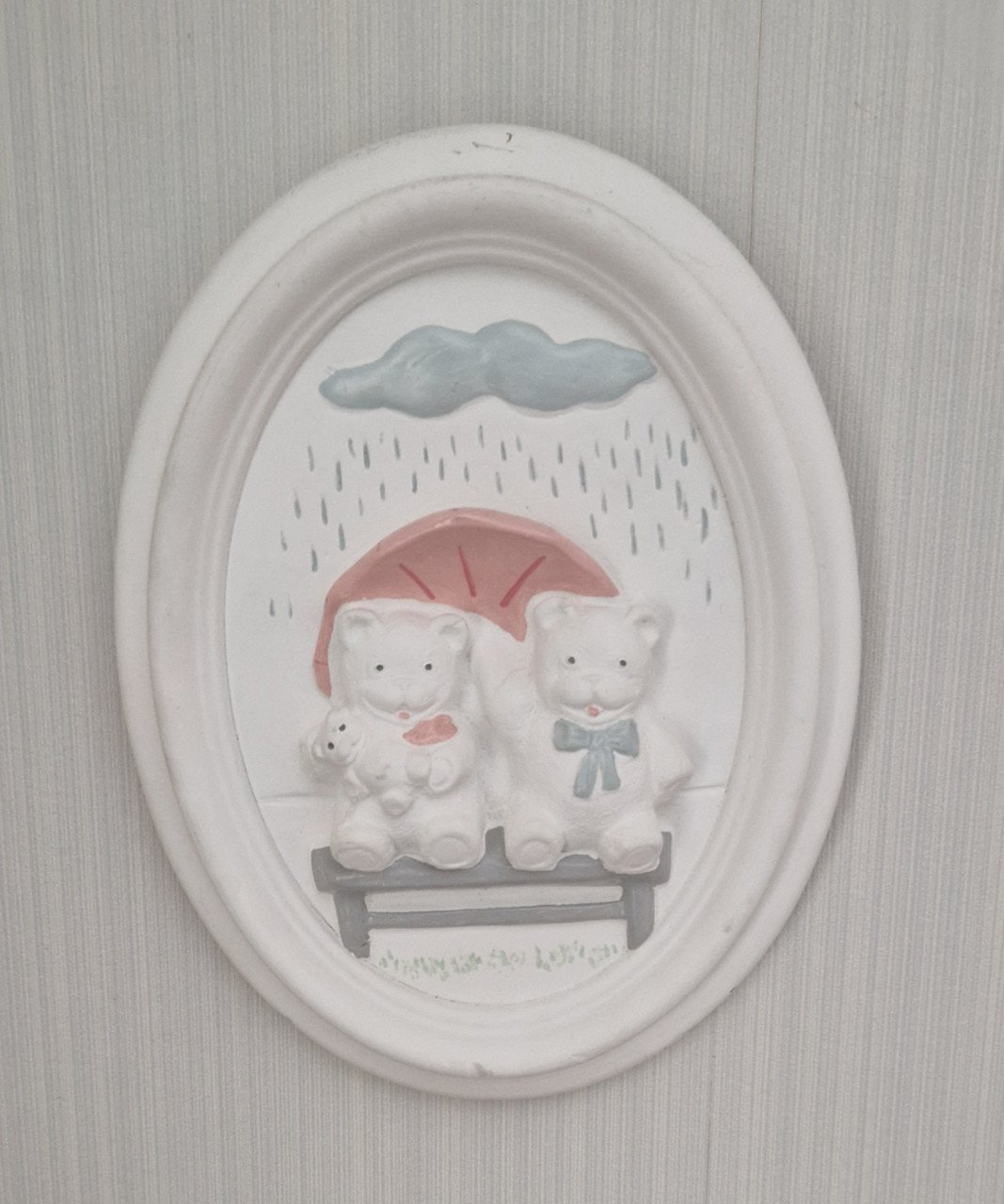 Schattige wanddecoratie van gips met 2 beertjes op een bankje in de regen
