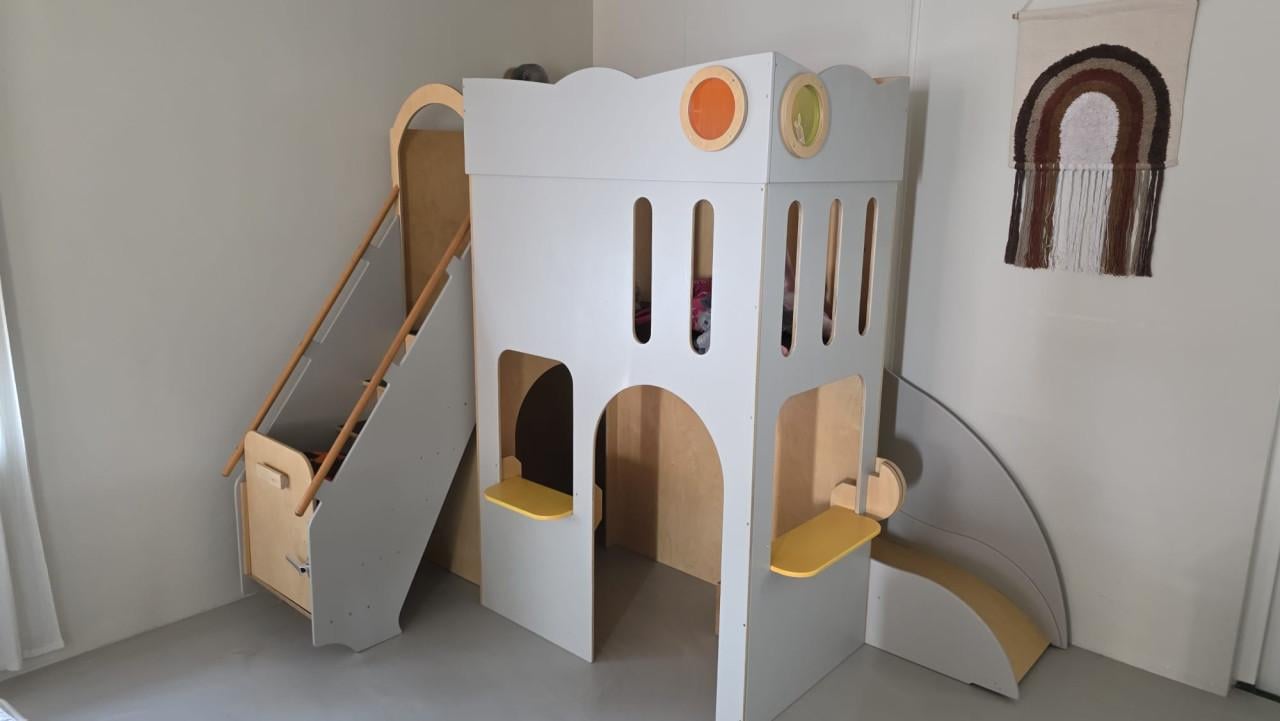 Speelhuisje binnen met glijbaan