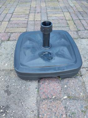 Nieuwe grijze parasolvoet met zand gevuld