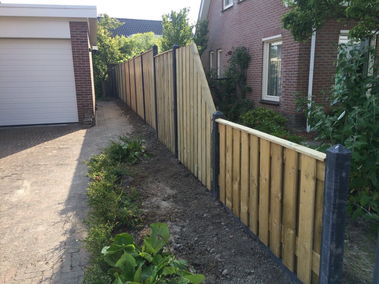 Nieuwe schutting geimpregneerd. gecoate palen en onderplaten.