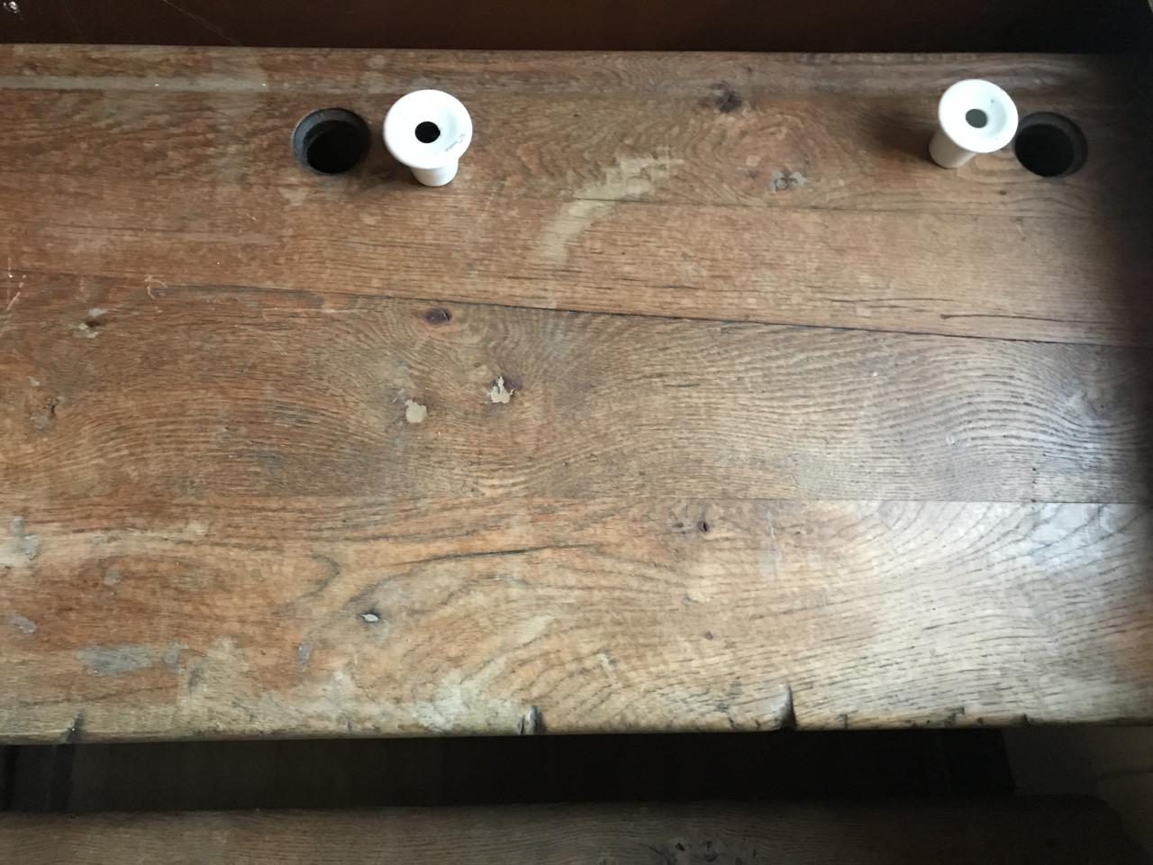 Oude schoolbank met porseleinen inktpotjes