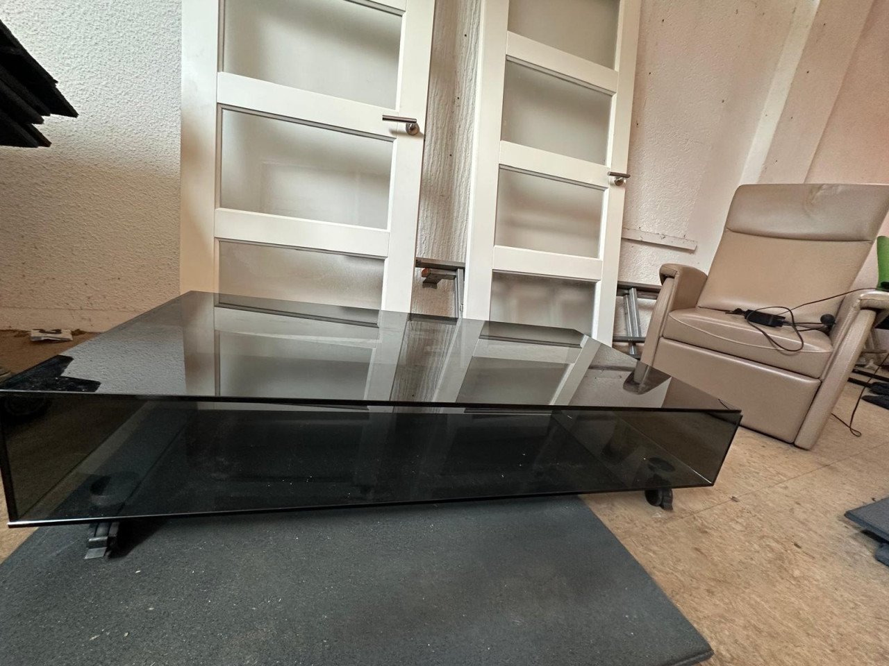 Relax fauteuil/ binnendeuren en een zwarte glazen tafel