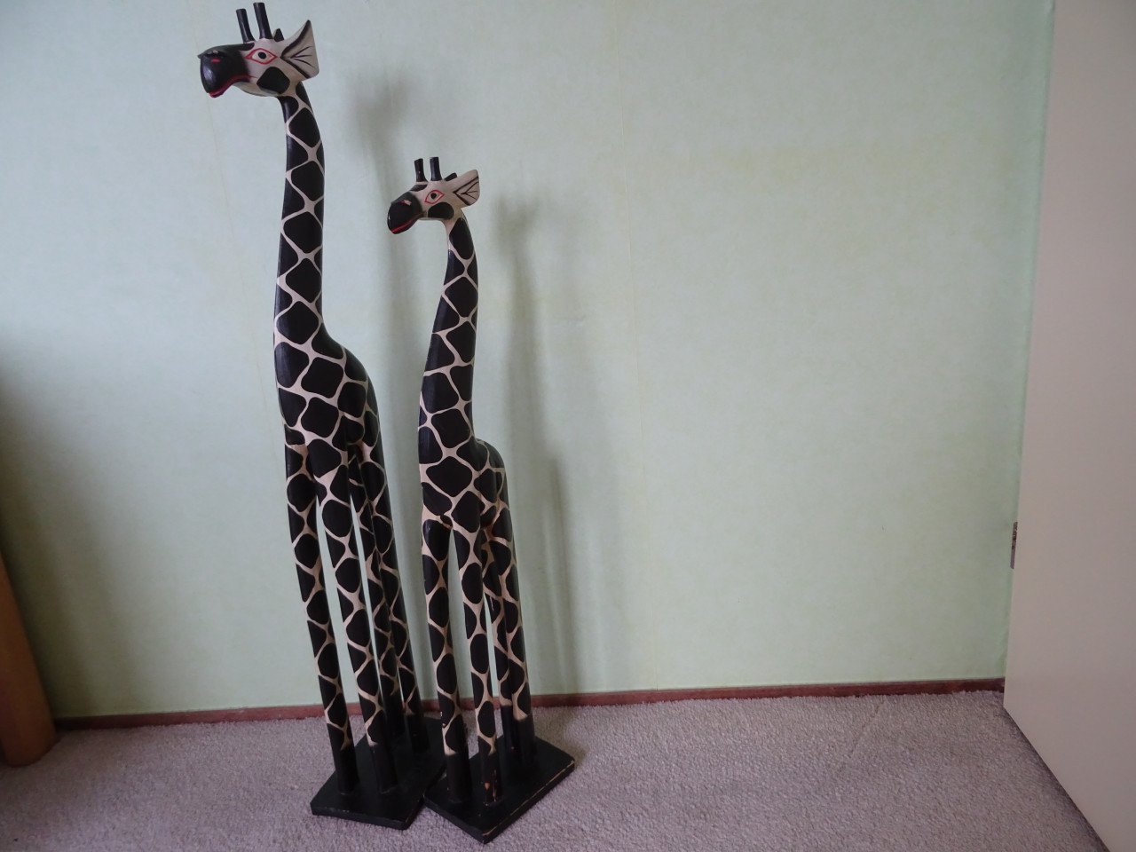 Twee giraffes van hout. Hoogte 98 cm.  Hoogte 80 cm.