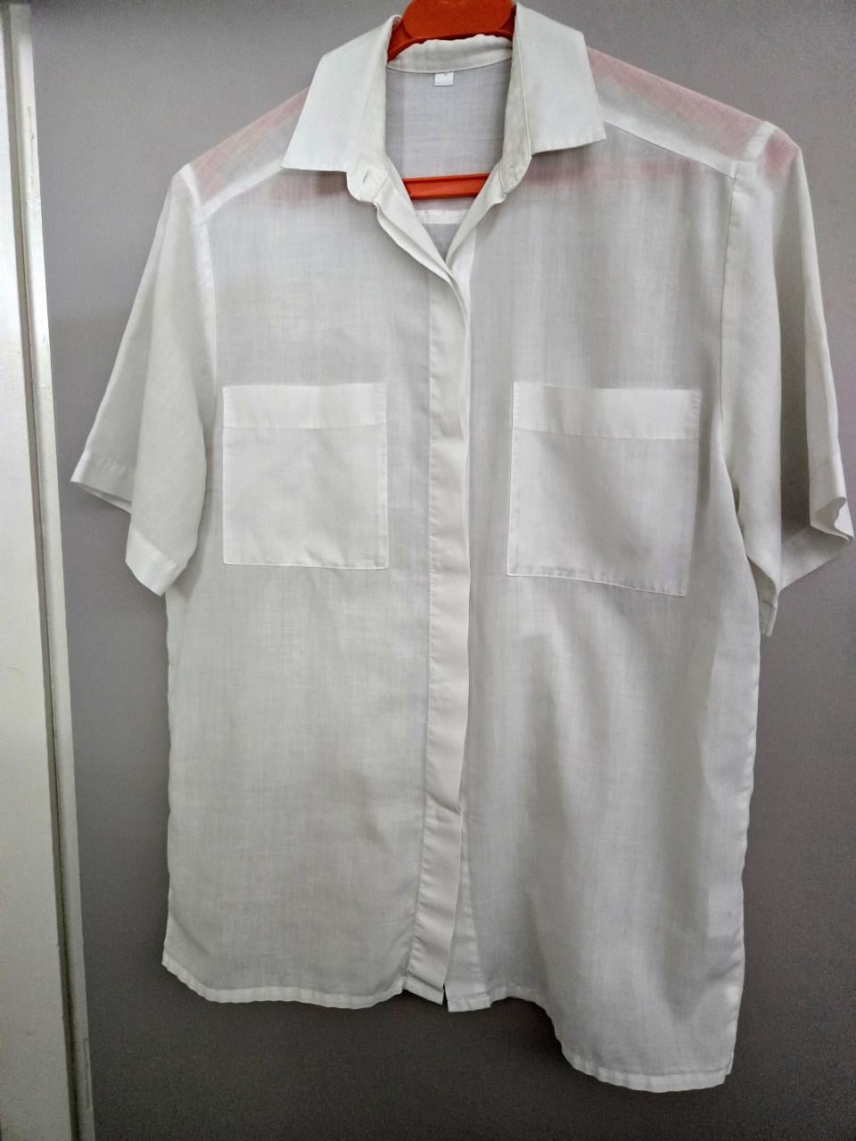 Witte blouse met korte mouwen en twee borstzakken.  Maat M