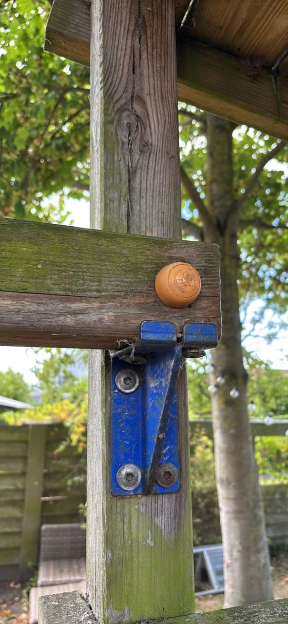 Houten speelhuis met glijbaan en schommels