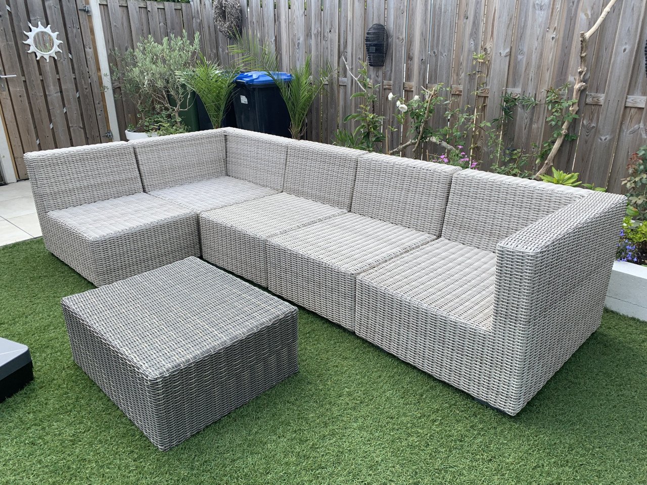 Rieten loungeset met kussens en tafel.