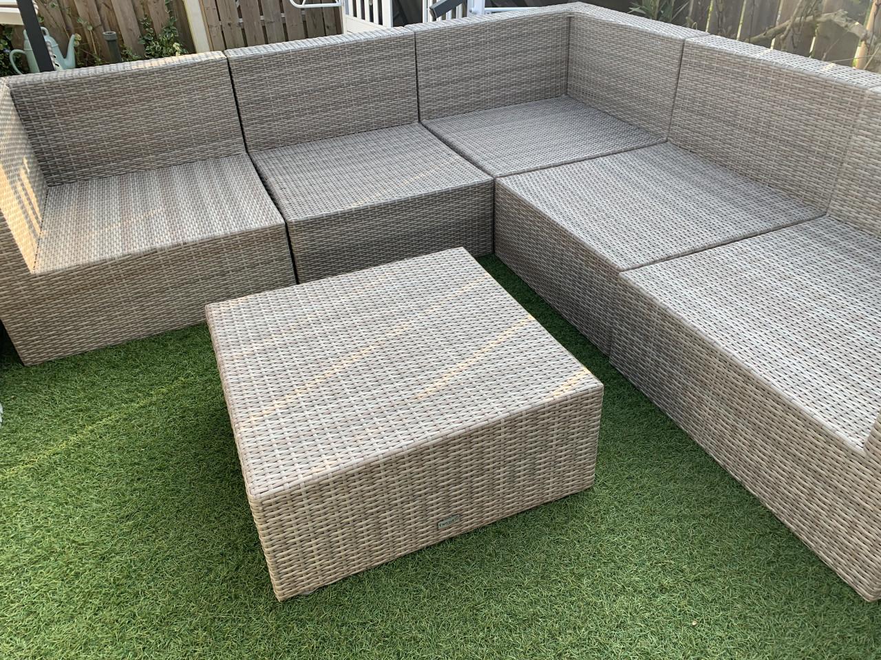 Loungset van pvc riet, met kussens en tafel.