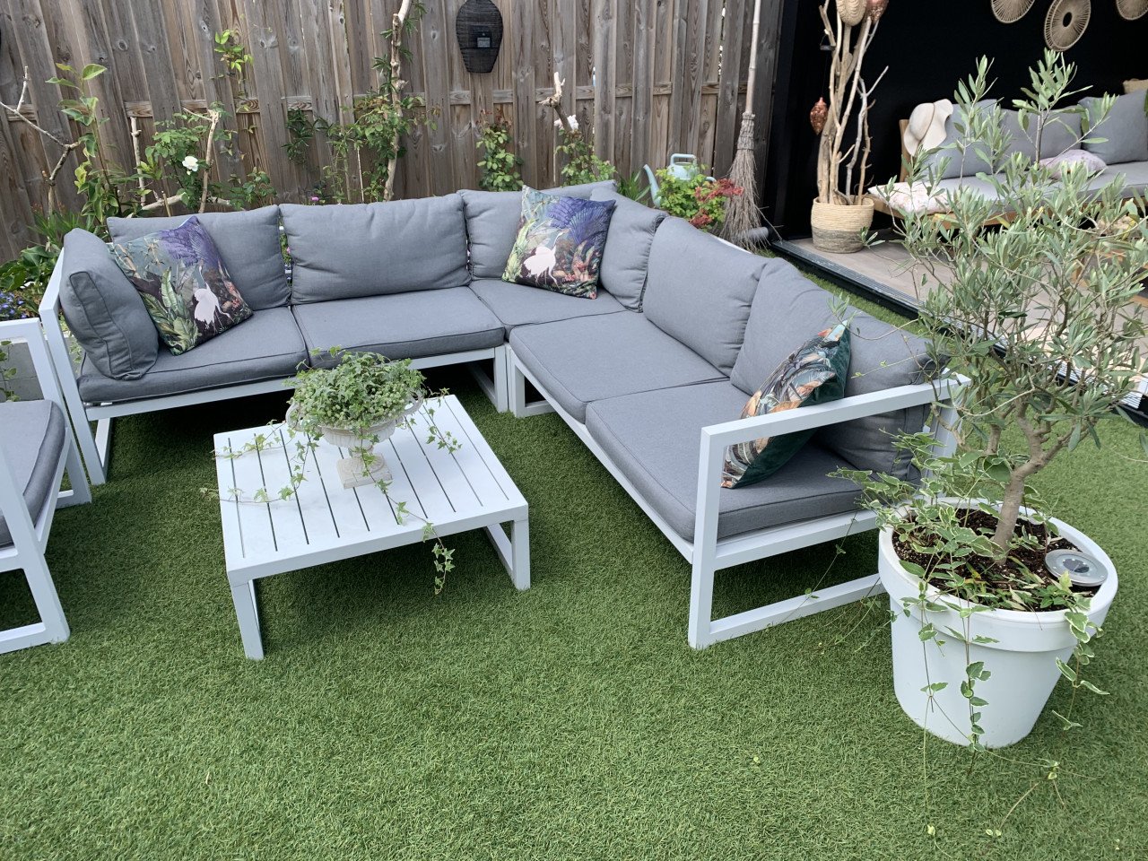 Wit aluminium loungeset met kussens tafel en stoel.