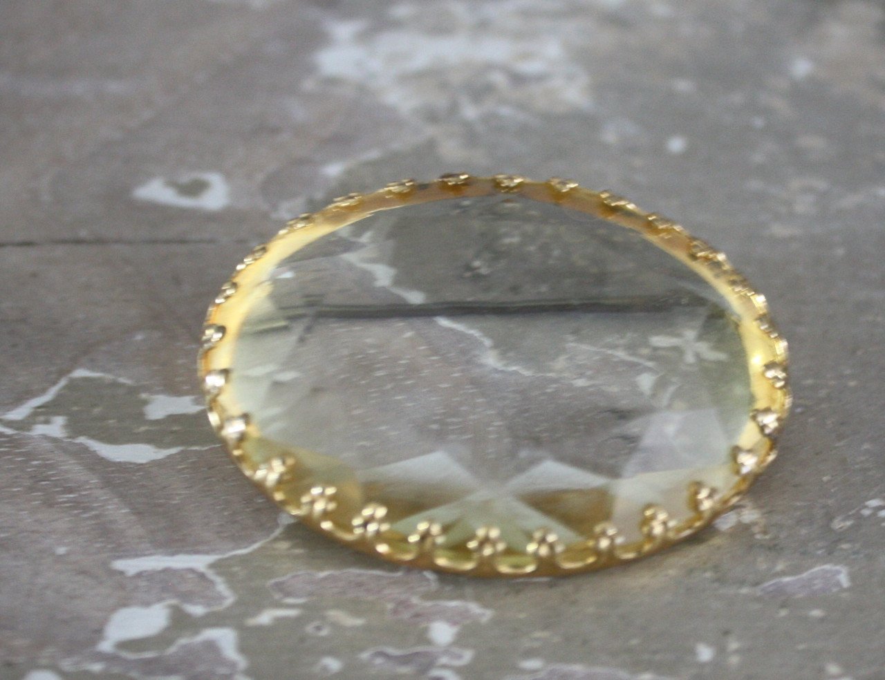 Goudkleurige broche met transarante steen