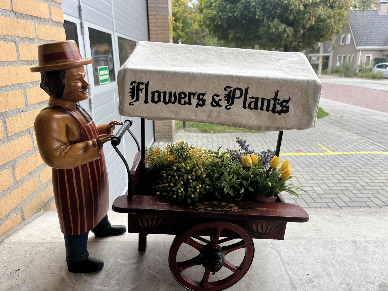 Miniatuur bloemkarretje met pop