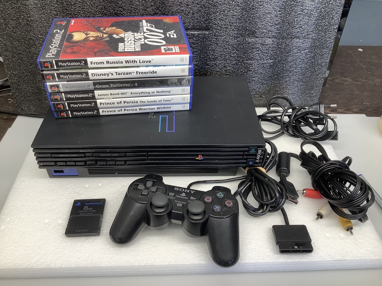 PlayStation 2 phat met 1 controller, geheugenkaart en 6 spellen.