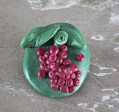 Groenen stenen boche met rode druiven struik