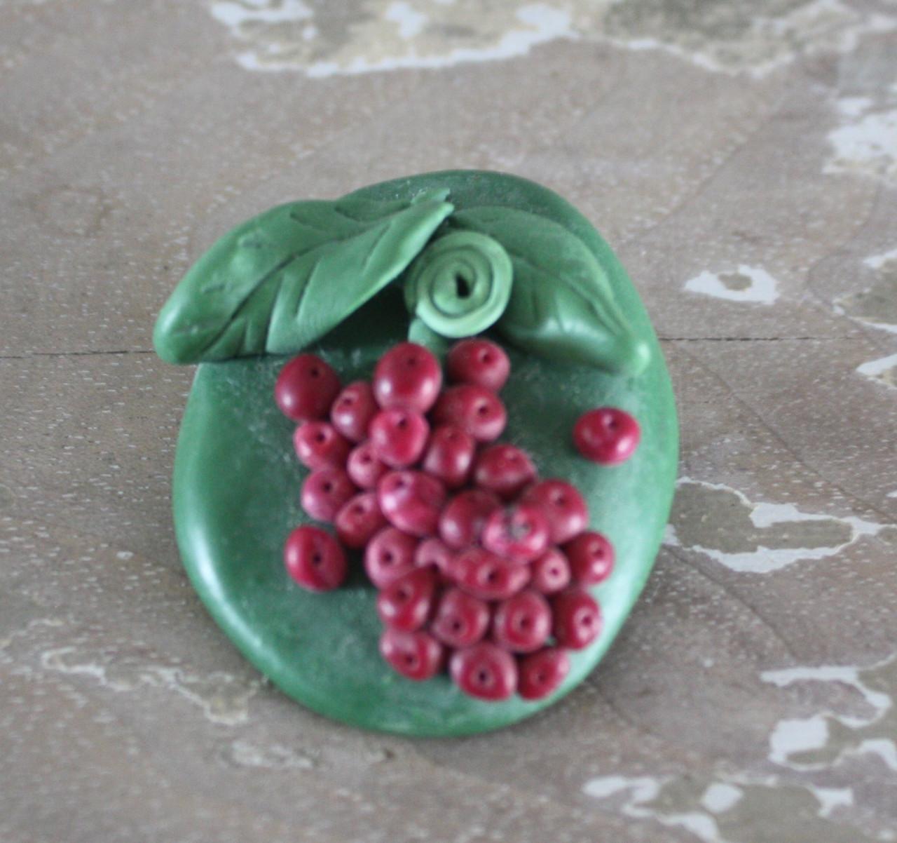 Groenen stenen boche met rode druiven struik