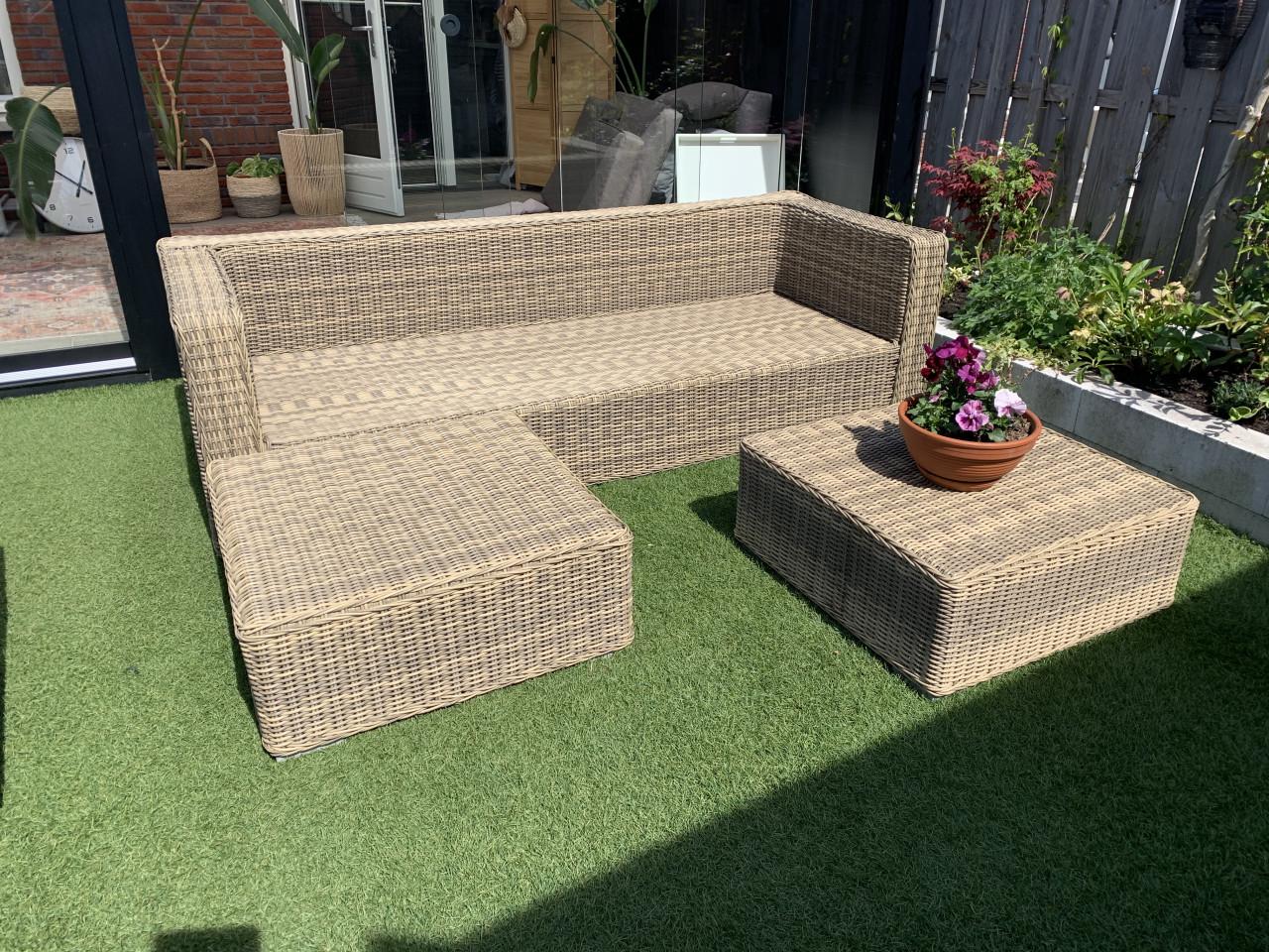 Rieten loungeset, met kussens en tafel.