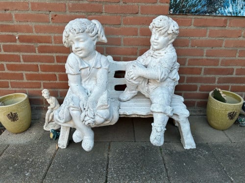 Betonnen beeldje op bankje