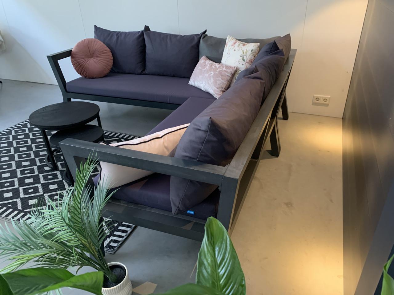 Loungeset, grijs aluminium, blauwe kussens en tafeltjes.