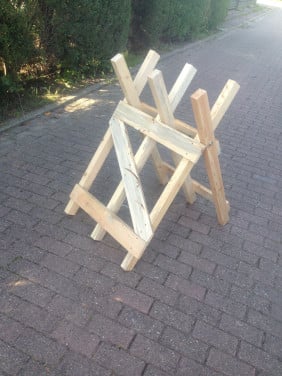 Rechtop hout doorzagen met kettingzaag en compacte zaagbok als werkbank