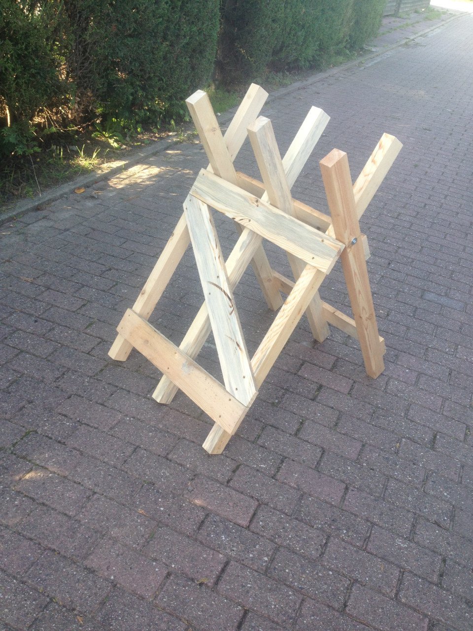 Rechtop hout doorzagen met kettingzaag en compacte zaagbok als werkbank