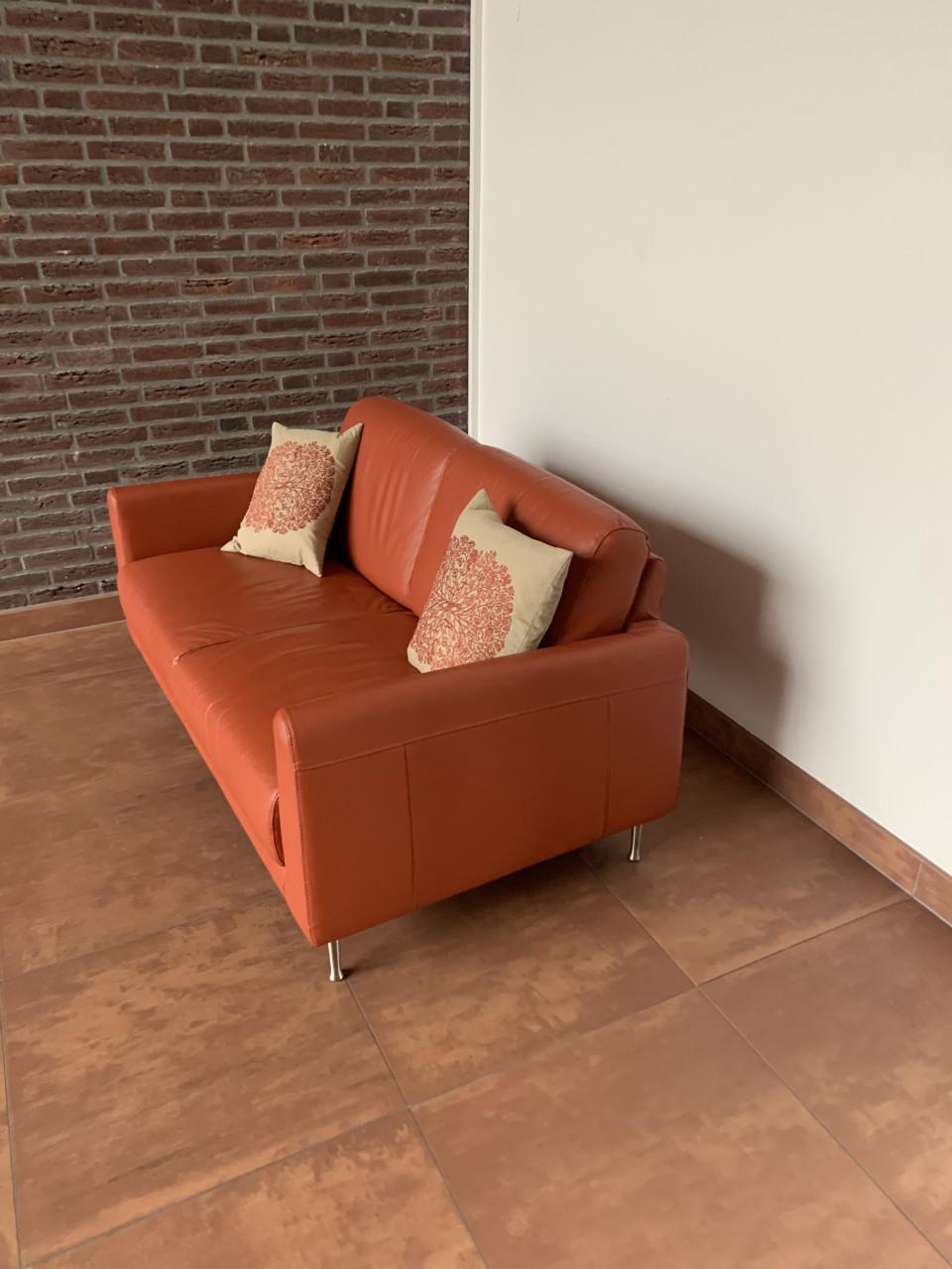 Leuk oranje kleurig bankje met twee kussens