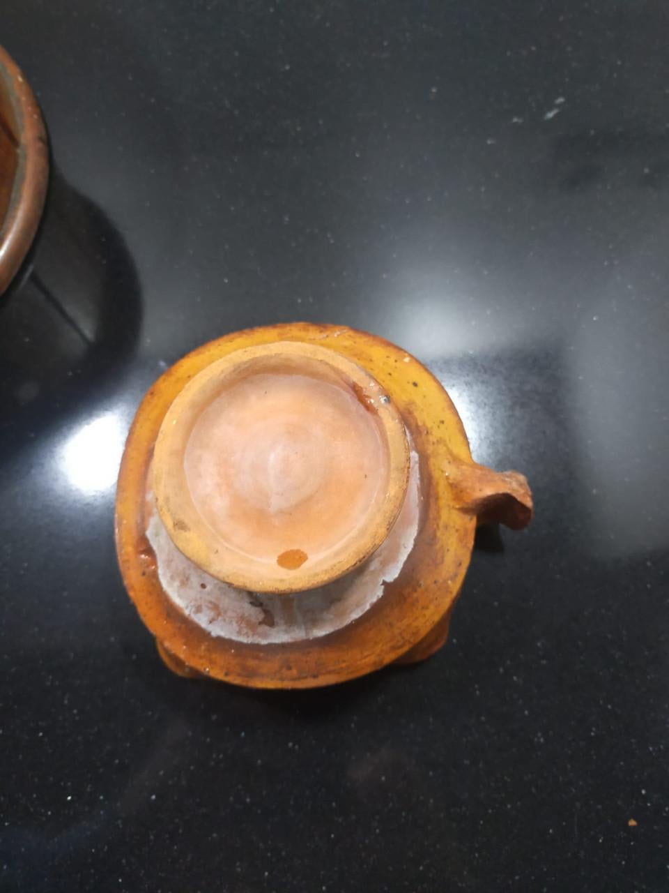Antieke ronde voetenstoof met aardewerk schaaltje