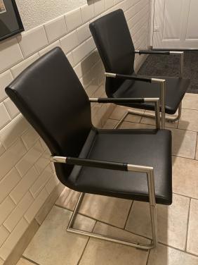 Twee zwarte leren stoelen