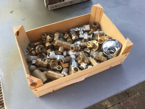 Doos met koperen koppelstukken en onderdelen