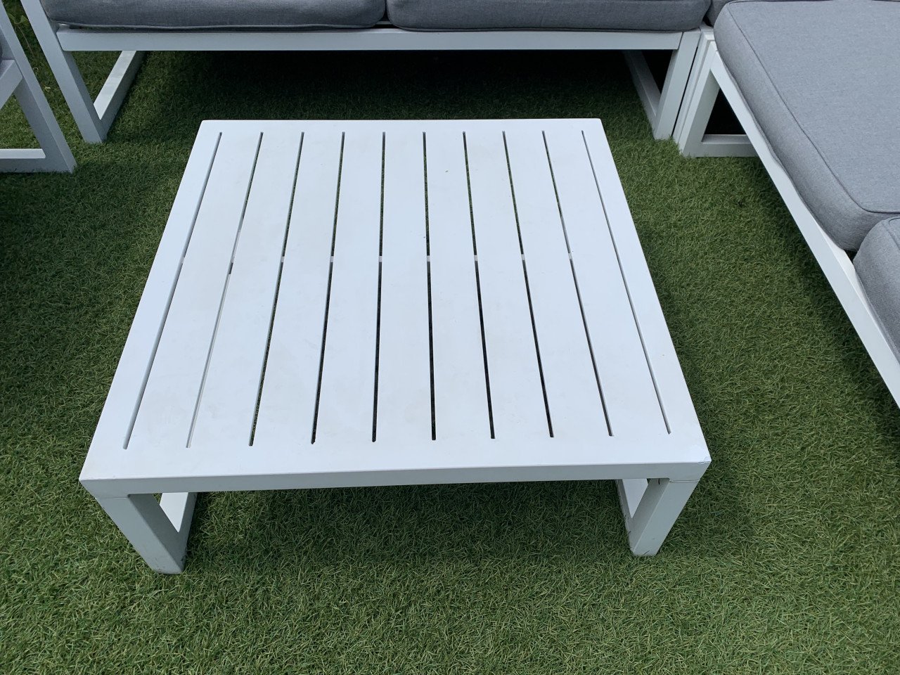 Wit aluminium loungeset met kussens tafel en stoel.