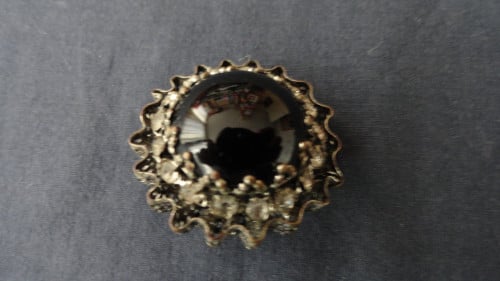 Speld met zwarte steen met strass steentjes eromheen. Leuk ding. (zie foto’